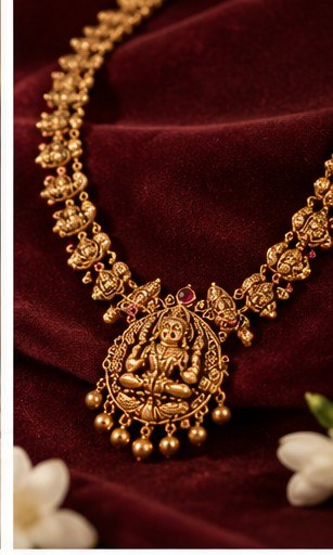 Gold temple-style Lakshmi pendant necklace on maroon velvet